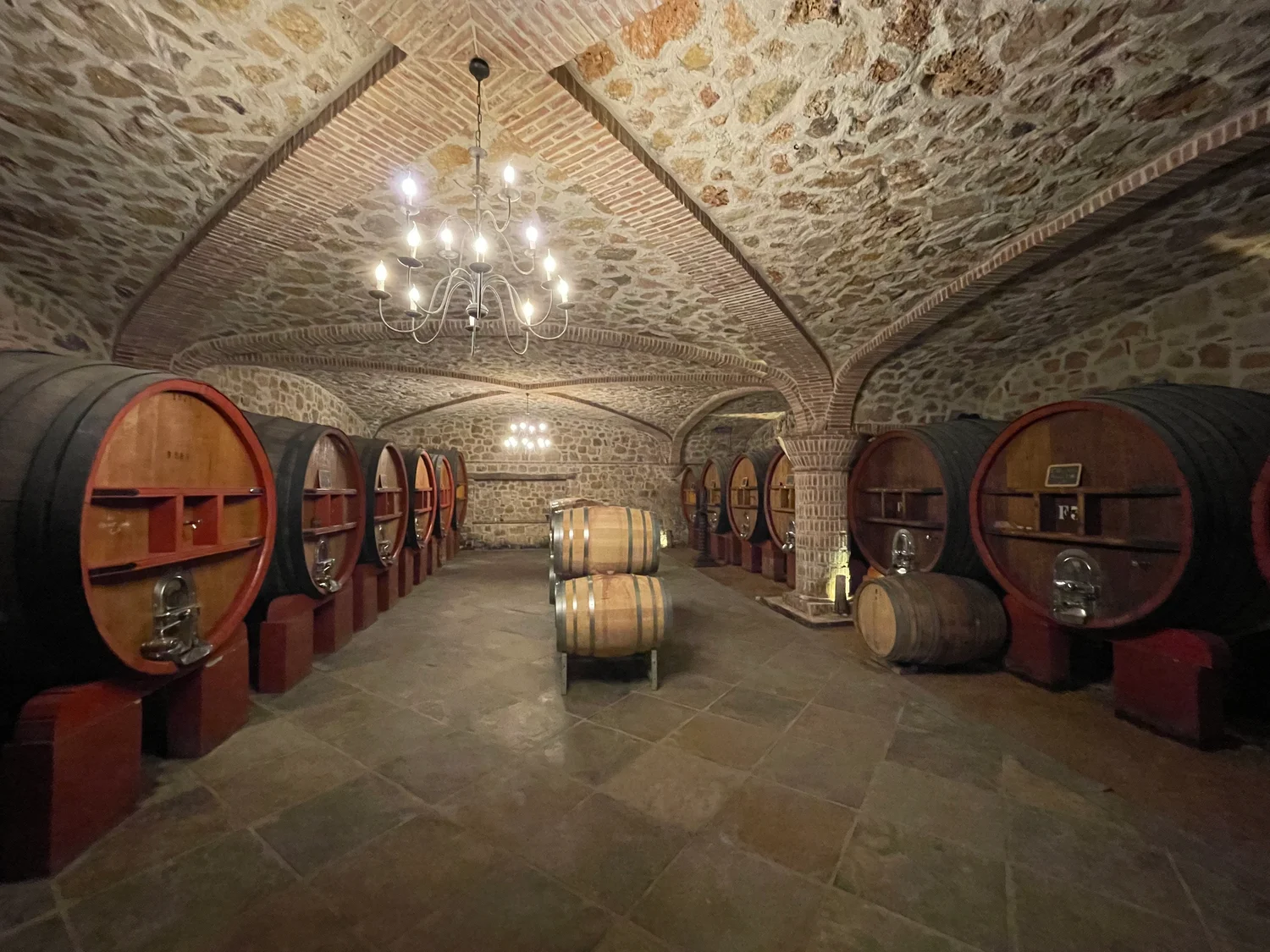 Stone vaults and large wooden casks in the cellars at Château Rasque